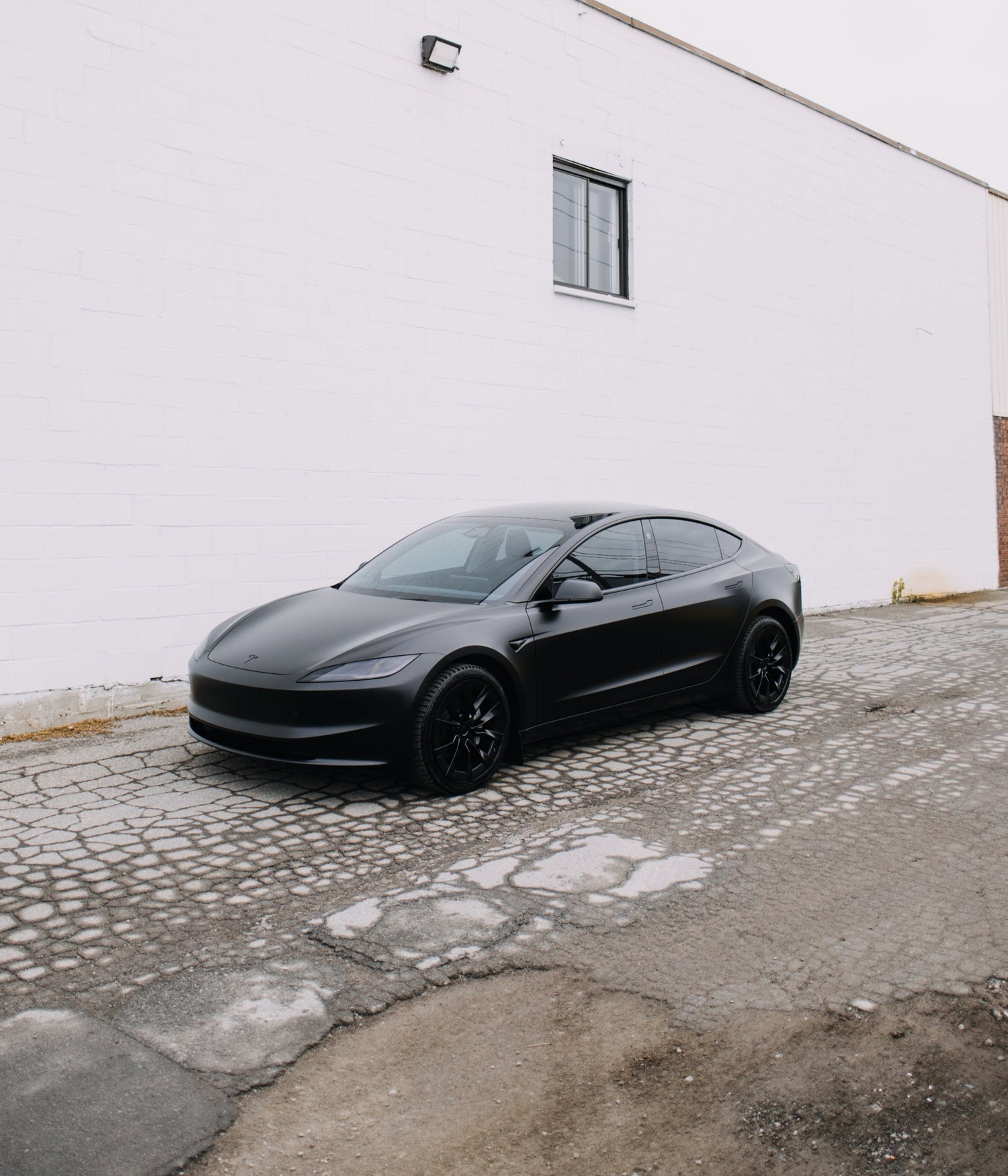 Angled view of a black wrapped Tesla Model 3